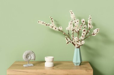 Odanın içinde çiçek açan dalları olan vazo.