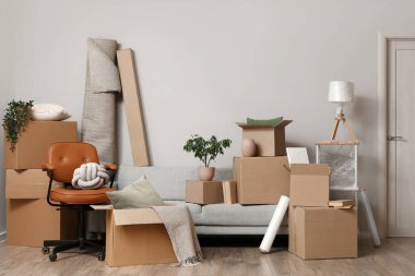 Taşınırken odada karton kutular olan mobilyalar.