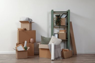 Taşındığı gün ışık duvarının yanında karton kutular olan raf ünitesi.