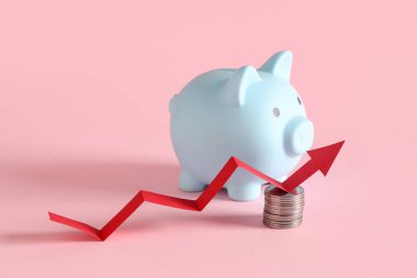 Pembe arka planda bozuk paralar ve ok olan kumbaralar. Artan fiyat kavramı