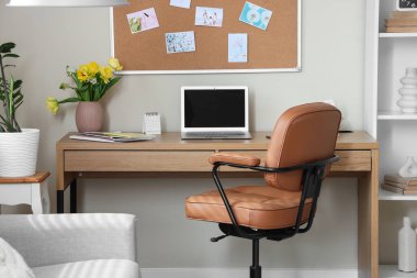 Boş dizüstü bilgisayar ve vazo. Ofisinde bahar çiçekleri var.