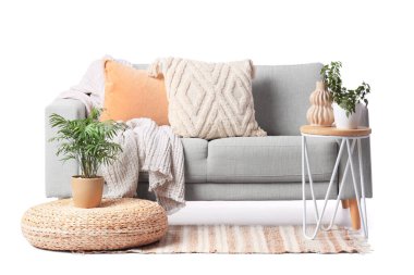 Masalı gri kanepe ve beyaz arka planda puf.