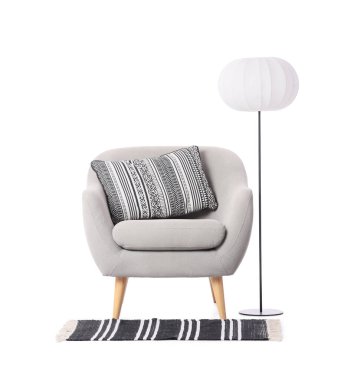 Beyaz arka planda lamba ve halı olan gri koltuk