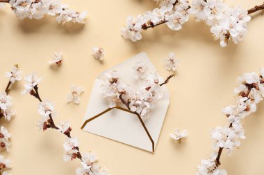 Zarfın içinde güzel ağaç dalları ve sarı arka planda çiçekler var.