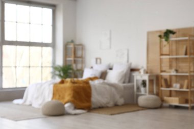 Katlanan ekran, raf üniteleri ve bitkilerle aydınlık yatak odasının bulanık görüntüsü