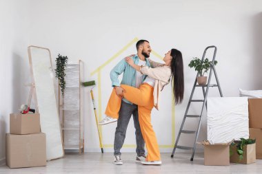 Taşındığı gün odada dans eden mutlu genç çift.