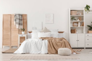 Katlanan ekran, masa ve raf üniteli aydınlık yatak odasının içi