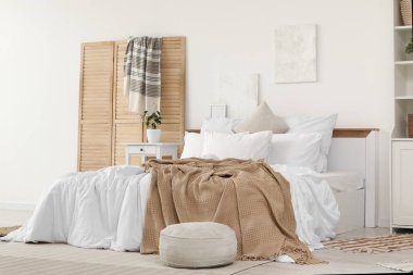 Katlanan ekran, puf ve resimlerle aydınlık yatak odasının içi