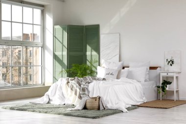 Yeşil ekran, bitkiler ve masa ile aydınlık yatak odasının içi