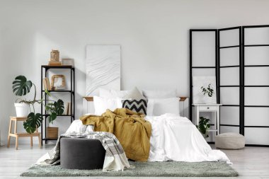 Katlanan ekran, kitaplık ve masa ile aydınlık yatak odasının içi