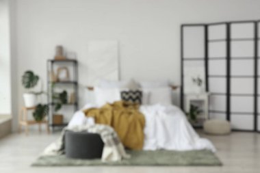 Katlanan ekran, kitaplık ve masa ile aydınlık yatak odasının bulanık görüntüsü