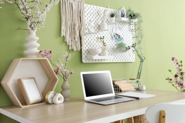 Çalışma alanı, tahta ve vazolarda çiçek açan dallarla birlikte ofis içi