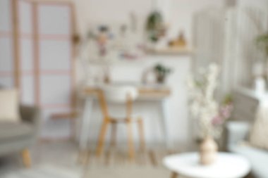 Çalışma yeri, tahta ve vazolarda çiçek açan dallarla aydınlık ofisin bulanık görüntüsü