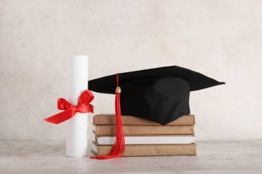 Beyaz arka planda kitap yığını ve diploması olan havan topu tahtası