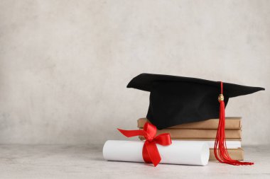 Beyaz arka planda kitap yığını ve diploması olan havan topu tahtası