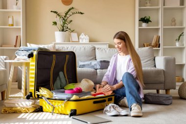 Evde bavul hazırlayan kadın turist