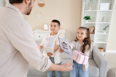 Mutlu baba evde küçük çocuklarından hediyeler alıyor.