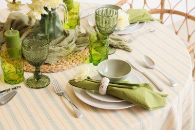 Narcissus çiçekleri, bardaklar ve katlanmış peçeteyle zarif bir masa.