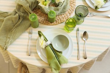 Narcissus çiçeği, mumlar ve katlanmış peçeteyle zarif bir masa.