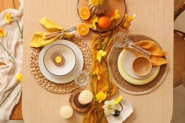 Narsisli güzel çiçekler, yanan mumlar ve taze portakallar, üst manzara.