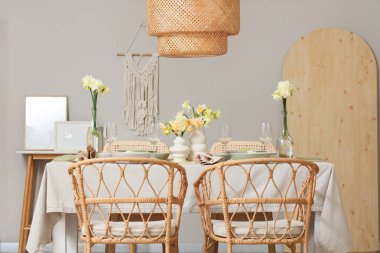 Narcissus çiçekleri ve bardakları hafif yemek odasında zarif bir masa.