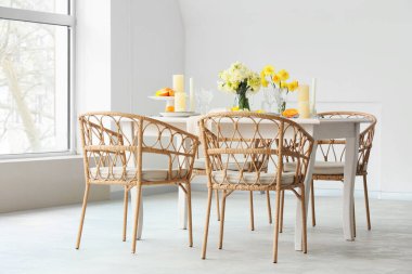 Narcissus çiçekleri ve hafif yemek odasında mumlarla süslenmiş zarif bir masa.