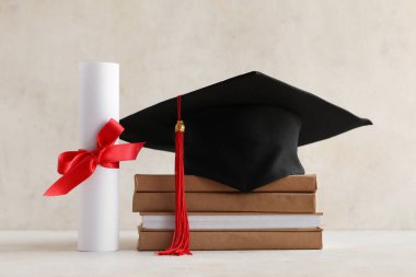 Mezuniyet şapkası, kitaplar ve açık arkaplan diploması.