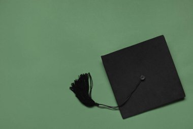 Yeşil arka planda mezuniyet şapkası, üst görünüm