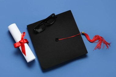 Mezuniyet şapkası, gözlükler ve mavi arka plan diploması.