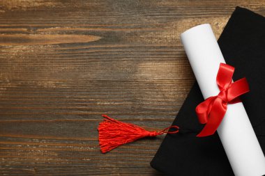 Mezuniyet şapkası ve diploması ahşap arka plan, üst görünüm