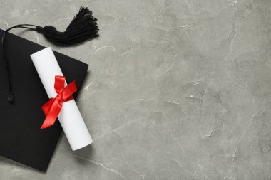 Mezuniyet şapkası ve gri arka plan diploması, üst görünüm