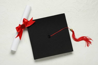 Mezuniyet şapkası ve diploması beyaz arka plan, üst görünüm