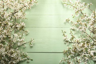 Soluk yeşil ahşap arka planda güzel çiçek açan ağaç dallarından yapılmış çerçeve