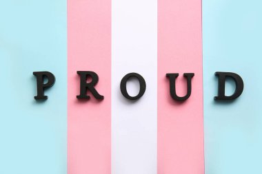 Transeksüel bayrağı arka plan olarak PROUD sözcüğü, yakın plan