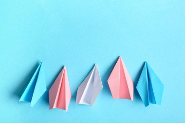 Mavi arkaplanda kağıt uçaklar şeklinde transseksüel bayrak renkleri