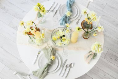 Narcissus çiçekleri ve mumlarla dolu güzel bir masa, üst manzara.