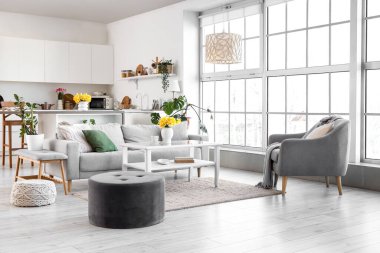 Mutfağın içinde tezgah, kanepe ve bahar çiçekleri var.