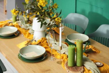 Gözlüklü, yanan mumlu, çiçek açan ağaç dallı zarif bir masa.