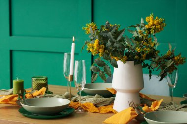 Gözlüklü, yanan mumlu, çiçek açan ağaç dallı zarif bir masa.