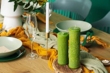 Mumlar, bardaklar ve çiçek açan ağaç dalları olan zarif bir masa. Yakın plan.