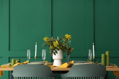 Gözlüklü, yanan mumlu ve çiçek açan ağaç dallı zarif bir masa.