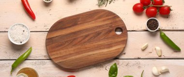 Açık ahşap arka planda kesim tahtası, baharat ve sebzelerle kompozisyon