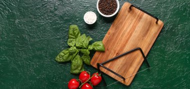 Ahşap mutfak tahtası, taze domates, fesleğen ve baharatlar.