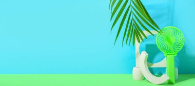 Taşınabilir elektrikli vantilatör, palmiye yaprağı ve renk arkaplanı üzerine sıva podyumları metin için alan