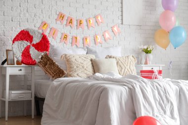 Yatak odasının içi balonlar, pinyatalar ve çelenklerle süslenmiş.