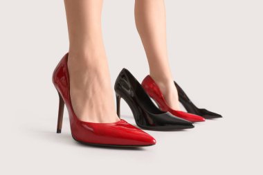 Gri arka planda kadın bacakları ve şık ayakkabılar.