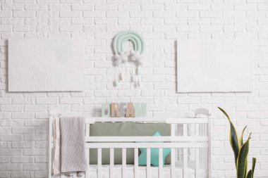 Bebek yatağı ve tabloları olan modern çocuk odası.