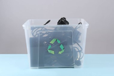 Renkli arka planda farklı ev aletleri olan geri dönüşüm kutusu