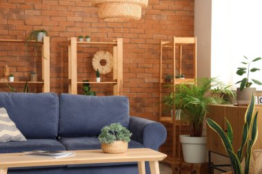 Rafları, masası, kanepesi ve çiçekleri olan çatı katı tarzı oturma odasının güzel bir iç mekanı.