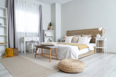 Büyük yataklı, raflı ve komodinli modern yatak odası.